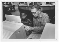 Photograph of a man showing a boy how to use a computer, Athens, Georgia, circa 2000