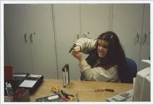Photograph of a woman trying to work on fixing a video tape at the library, Athens, Georgia, circa 1995