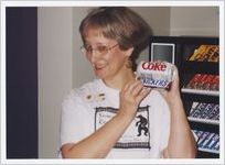Photograph of a woman at the library showing off snacks from the vending machine, Athens, Georgia, circa 1995