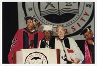Thomas W. Cole, Jr. with Unidentified Men and Woman on Stage at Commencement, 1997