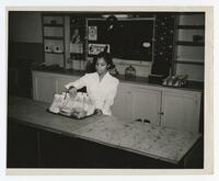 An Unidentified Woman Behind a Counter, circa 1960