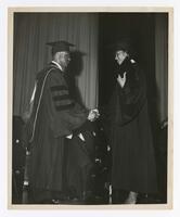 A Graduate Shakes Hands With James P. Brawley on stage at Commencement, circa 1965