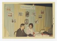 An Unidentified Man and an Unidentified Woman at Table at the Clark College Exhibit, December 1966