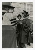 An Unidentified Graduate Receives Her Diploma at Commencement, circa 1965