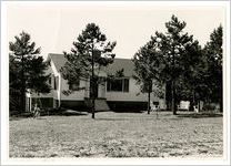 Photograph of the exterior of a house with a young child and dog standing in the front yard, Clarkesville, Habersham County, Georgia