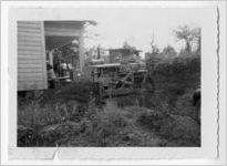 Photograph of a man operating a bulldozer next to a wooden building, Clarkesville, Habersham County, Georgia, 1953