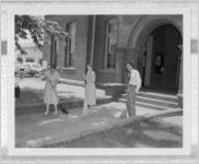 Photograph of two women and a man sweeping a walkway in front of a building, Clarkesville, Habersham County, Georgia, 1953