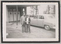 Photograph of man and boy reading a booklet beside a car, Clarkesville, Habersham County, Georgia, 1950