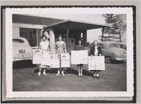 Photograph of a group of young women  involved with a school cleanup campaign standing in front of a building holding posters, Clarkesville, Habersham County, Georgia, 1950