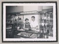 Photograph of a North Habersham High School student working behind a shop counter selling cameras, Clarkesville, Habersham County, Georgia, 1950