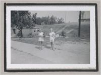 Photograph of two girls standing on a paved walkway, Clarkesville, Habersham County, Georgia, 1950