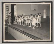 Photograph of children gathered around a teacher on a performance stage, Clarkesville, Habersham County, Georgia, 1950