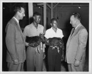 Photograph of two young African American men with award winning poultry at the Georgia State Fair, Macon, Bibb County, Georgia, 1953