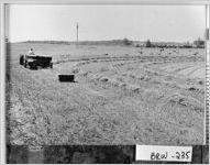 [Photograph of farm worker on the McElhannon farm baling lespedeza, Barrow County, Georgia, 1956]