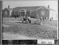 [Photograph of students in process of planting Bermuda grass on the grounds of Holsenbeck School, Barrow County, Georgia, 1952]