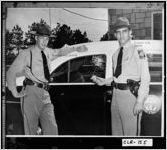 [Photograph of troopers D. S. Harris and H. H. Popham standing by their patrol car, Washington, Wilkes County, Georgia, 1952 June]