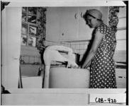[Photograph of a woman using a wringer type washing machine, Lost Mountain Community, Cobb County, Georgia, 1949]