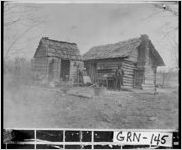 [Photograph of a cabin with its two African-American owners in front, Union Point, Greene County, Georgia, ca. 1900]