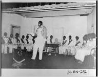 [Photograph of a minstrel performing as others watch, Siloam, Greene County, Georgia, 193-]