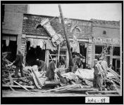 [Photograph of people shifting through the debris in front of the office of 
				
				, Gainesville, Hall County, Georgia, 1936 Apr. 6 ]