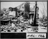 [Postcard of a man standing amidst a destroyed house and debris, Gainesville, Hall County, Georgia, 1936 Apr. 6]