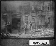 [Photograph of three blacksmith helpers, Robert F. Howell, Henry Howell, the Chief of Police, and an unidentified man in front of Howell and Son, Blacksmith and Repair Shop, Hartwell, Hart County, Georgia, ca. 1909]