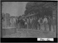 [Photograph of men gathered around artesian well at the intersection of Houston and Commerce Streets, Hawkinsville, Pulaski County, Georgia, ca. 1900]