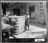 [Photograph of workers at the Troup County Warehouse receiving and tagging bales of cotton, LaGrange, Troup County, Georgia, ca. 1927]