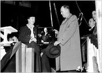 [Photograph of Emil J. Kratt holding a photograph of Howard E. Coffin at the launching of the Liberty ship Howard E. Coffin, J.A. Jones Construction Company shipyard, Brunswick, Georgia, 1944 Jan. 21?]
