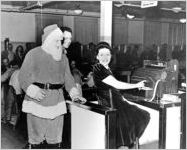 [Photograph of Santa watching as Myrtis Campbell counts all the workers, 1944 Dec. 25]