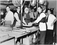 [Photograph of the kitchen crew preparing dinner with Santa looking on, J.A. Jones Construction Company shipyard, Brunswick, Georgia, 1944 Dec. 25]