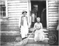 [Photograph of African American couple in front of woooden house with open door in or near Richmond County, Ga., in late 19th century]