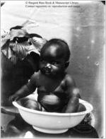 [Photograph of baby sitting in small wash basin in or near Richmond County, Georgia, late 19th century]