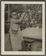 Photograph of pageant director Arden Peting picking cotton during the Worth County Centennial Celebration in Sylvester, Worth County, Georgia, 1953 October