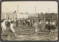 Photograph of Jill Cochran and other children with hats on walking on the field at the Sylvester High School stadium during the Worth County Centennial Celebration in Sylvester, Worth County, Georgia, 1953 October