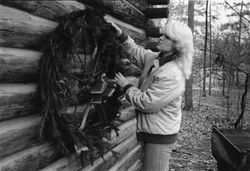 Photograph of a Berry student decorating the Original Cabin for Christmas, Mount Berry, Georgia, 19XX