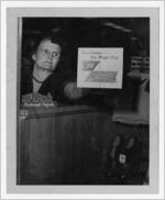 Photograph of a woman displaying a contest sticker at a clothing store, Manchester, Georgia, 1953