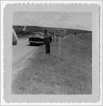Photograph of a police officer erecting a sign on a roads into town, Manchester, Georgia, 1953
