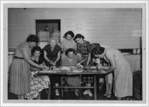 Photograph of a group of women gathered around a table working on decorations, Manchester, Georgia, 1953