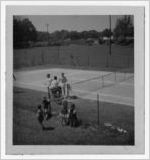 Photograph of the boys tennis team waiting by the side of the court, Manchester, Georgia, 1953