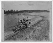 Photograph of a farmer driving a tractor in a curved pattern to prevent erosion, Manchester, Georgia, 1953