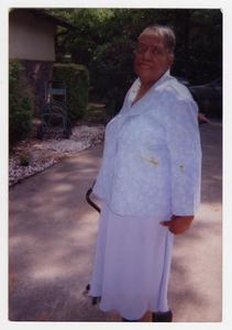 Color photograph of an unidentified elderly African American woman posing while standing with a cane