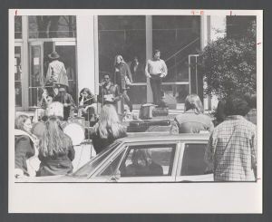 Students, groups, 1970s - Crowd listening to a speaker outside with band nearby