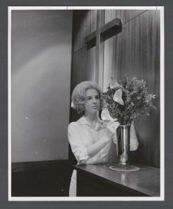 School of Nursing - Nurse adjusting flowers in a chapel