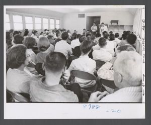 Students, groups, 1960s - Students in class listening to two speakers