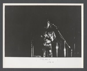 Students, groups, 1970s - Student by microphone with drumsticks during a musical performance