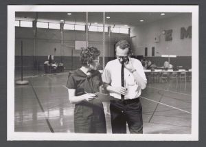Registration - Two administrators talk in the gym
