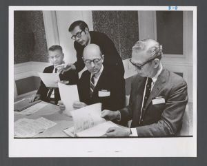 Business School - Dean Myers and others looking at documents