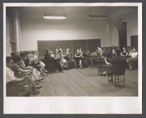 Dances and festivals - Group listens to woman playing guitar