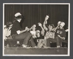 Fraternity Candidates - Sigma Chi students drinking milk on a stage